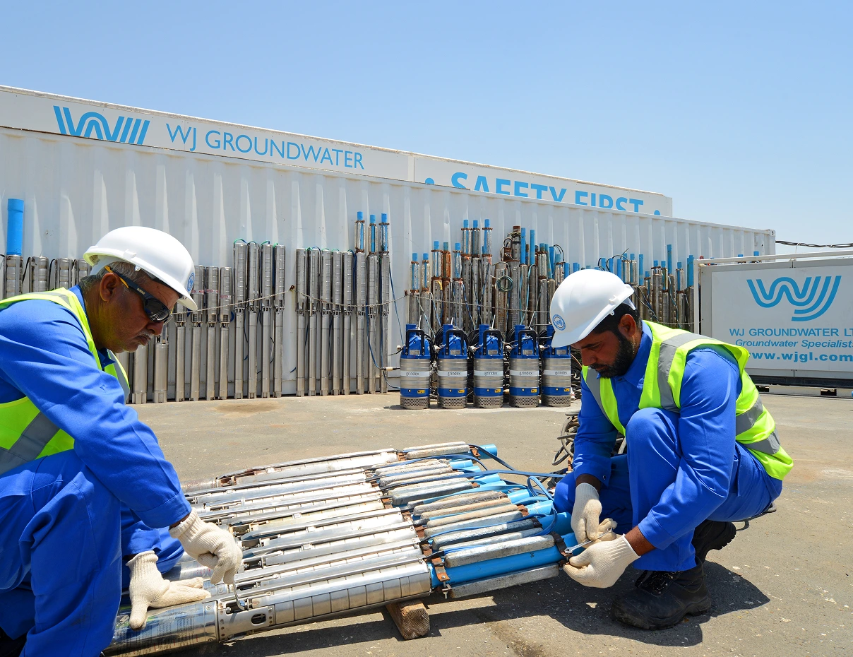 WJ Groundwater technicians inspecting groundwater equipment at a construction site.